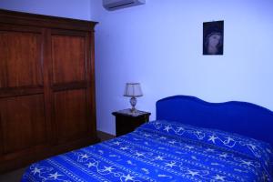 a bedroom with a blue bed with a blue comforter at B&B La Piccola Oasi in Lazzaro