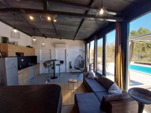 a living room with a couch and a kitchen at Casa di Ljubica - Private paradise in Pula - Luxury and romance for couples, jacuzzi, massage, pool, bbq and fenced yard in Pula