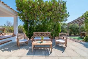 a patio with two benches and a table at Mallorquin Oasis with natural pool 5min from the beach in Port de Pollensa