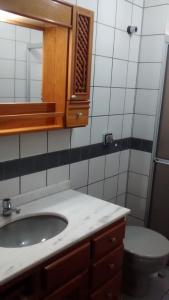 a bathroom with a sink and a toilet at Larus 107 in Florianópolis