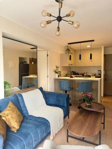 un salon avec un canapé bleu et une cuisine dans l'établissement Departamento de Lujo en Zona Financiera y Centrica, à San Antonio