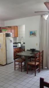 a kitchen with a table and chairs and a refrigerator at Larus 107 in Florianópolis