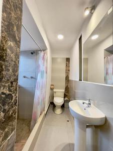 a bathroom with a white toilet and a sink at Casa Justina in Cusco