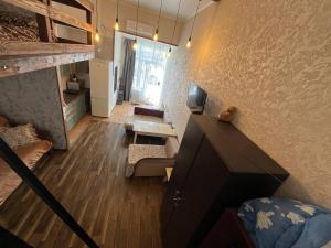 a living room with a staircase and a living room with a couch at Студия лофт in Chornomorsk