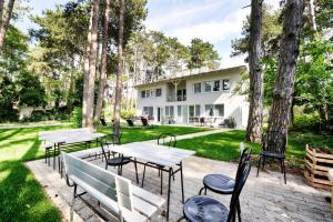 eine Terrasse mit Tischen und Stühlen vor einem Haus in der Unterkunft Villa Oliver 2 Siófok in Siófok