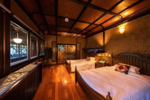a bedroom with two beds and a balcony at Nihon-no-Ashitaba in Yufu