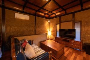 a living room with a couch and a flat screen tv at Nihon-no-Ashitaba in Yufu