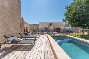 eine Terrasse mit Liegestühlen und einem Pool in der Unterkunft Ferme La Clavière, Maison de vacances Lou Mas in Mane