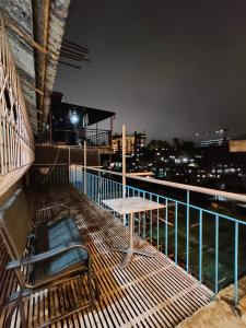 a table and a bench on a balcony at night at Soc Transient House by Grinta Property Rental in Baguio