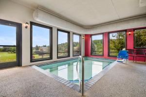a swimming pool with a blue chair and windows at Super 8 by Wyndham Eveleth in Eveleth