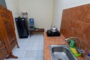 a kitchen with a sink and a counter top at GRIYA HARMONI Homestay Jogja in Adi Sutjipto