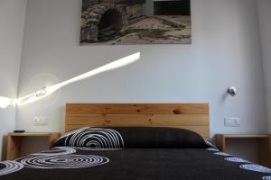 a bedroom with a bed with a wooden headboard at hostal restaurante aguilar in Forcall