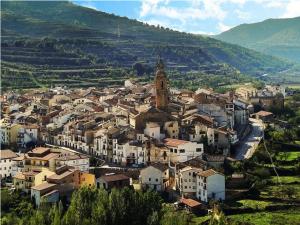 a small town with a clock tower on a hill at hostal restaurante aguilar in Forcall