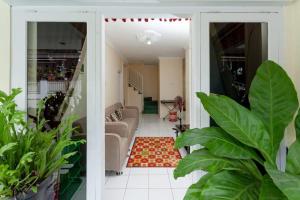 an open door into a living room with plants at GRIYA HARMONI Homestay Jogja in Adi Sutjipto +3 photos