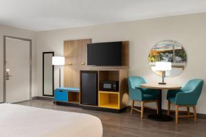 a hotel room with a bed and a table and chairs at Days Inn by Wyndham Worland in Worland