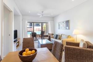 una sala de estar con una mesa con un bol de naranjas en Oaks Broome Hotel en Broome