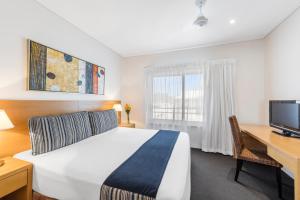 
a hotel room with two beds and a television at Oaks Broome Hotel in Broome
