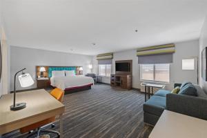 a hotel room with a bed and a couch at Hampton Inn & Suites Madera in Madera +36 photos