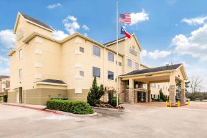a hotel with an american flag in front of it at Comfort Suites in Humble