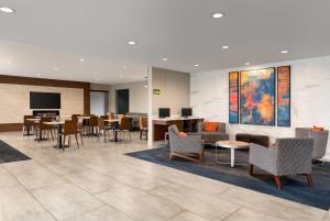a lobby with tables and chairs and a waiting room at La Quinta by Wyndham Montgomery in Montgomery