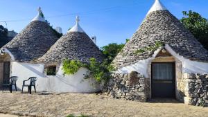 a couple of small stone buildings with pointed roofs at Tenuta Antico Leccio in Gioia del Colle