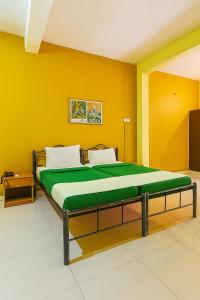 a large bed in a room with yellow walls at Hotel Osine in Panaji