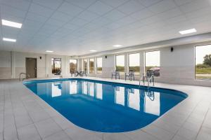 a large pool with blue water in a building at Days Inn and Suites by Wyndham Hammond, IN in Hammond
