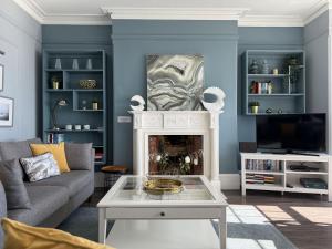a living room with a couch and a fireplace at The Eastleigh in Seaton