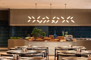 un restaurant avec des tables et des chaises et un buffet dans l'établissement Hilton Garden Inn Olympic Sports Center Jinan, à Jinan