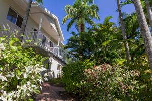 a house with a balcony and palm trees at Port Douglas Plantation Resort in Port Douglas