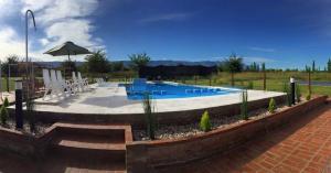 a swimming pool with chairs and an umbrella at Casonas de Nono in Nono