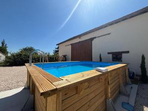 einen Pool mit einer Holzterrasse und einem Pool in der Unterkunft Domaine en bord de saone in Pagny-le-Château