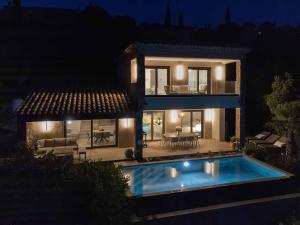 a house with a swimming pool in front of it at night at Villa L'Emeraude in Cavalaire-sur-Mer