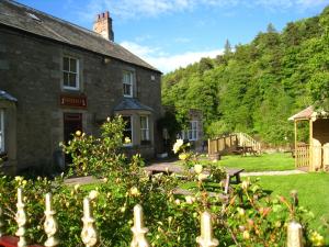 an old stone house with a garden in front of it at The Elks Head Inn in Whitfield