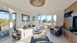 a living room with a white couch and chairs at Le Cocon d'Andernos Rooftop et Sea View in Andernos-les-Bains