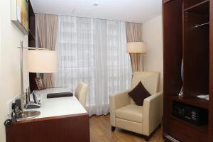 香港にあるアパートメント 218のデスクと椅子が備わるホテルルームです。
