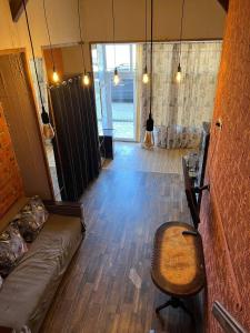 una sala de estar con un sofá y una silla en Стадия лофт 2, en Chornomorsk