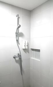 y baño con ducha y azulejos blancos. en 950 Condotel en Ángeles