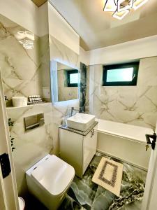 a bathroom with a toilet and a sink and a tub at Luxury Towers Loft in Iaşi +47 photos