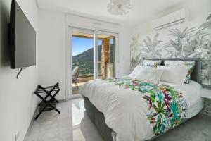 a bedroom with a bed and a tv and a window at Villa L'Emeraude in Cavalaire-sur-Mer +28 photos