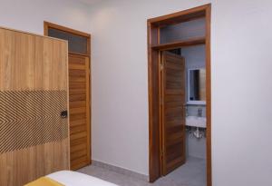 a bedroom with two wooden doors and a sink at Serene Apartments in Kigali +23 photos
