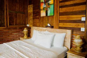 a bed with white sheets and pillows in a bedroom at Alain rooms AMED in Amed +17 photos