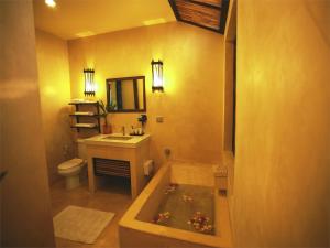 a bathroom with a tub with a sink and a toilet at IngNatee Resort in Pathum Thani +41 photos
