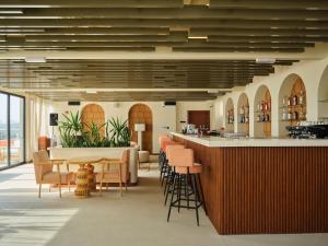 a restaurant with a bar with chairs and tables at The Muse in Doha