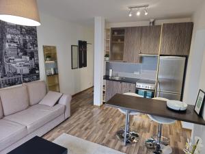 a living room with a couch and a table in a kitchen at Cozy Little Penthouse Free Parking, Self Check In in Tallinn