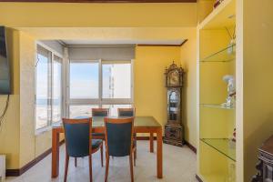 a dining room with a table and a clock at T2 na Caparica vista Praia in Costa da Caparica