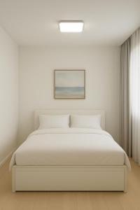 a white bedroom with a white bed and a picture at Near Seoul Station, Myeongdong, Itaewon, N seoul tower in Seoul