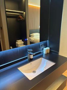 a bathroom counter with a sink and a mirror at Xihe Langyue Hotel Beijing Changying Tianjie Branch in Beijing