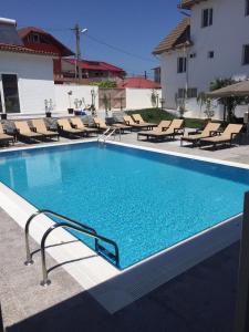 a swimming pool with chaise lounge chairs and a swimming pool at Hotel MaRailiS Mangalia in Mangalia