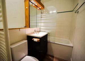 a bathroom with a sink and a toilet and a tub at Résidence Le Mustag - 3 pièces 6 personnes - LE MUSTAG -026MU- PLAGNE CENTRE MAE-0283 in Aime La Plagne